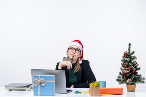 girl sitting and working with christmas cap